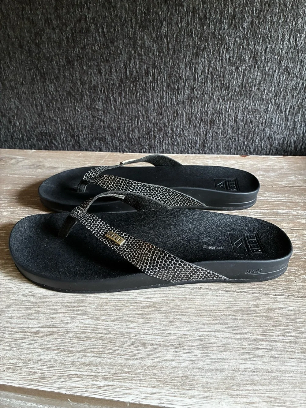 Reef Black Cushion Court Flip Flops with Snakeskin-Pattern Straps and Gold Logo